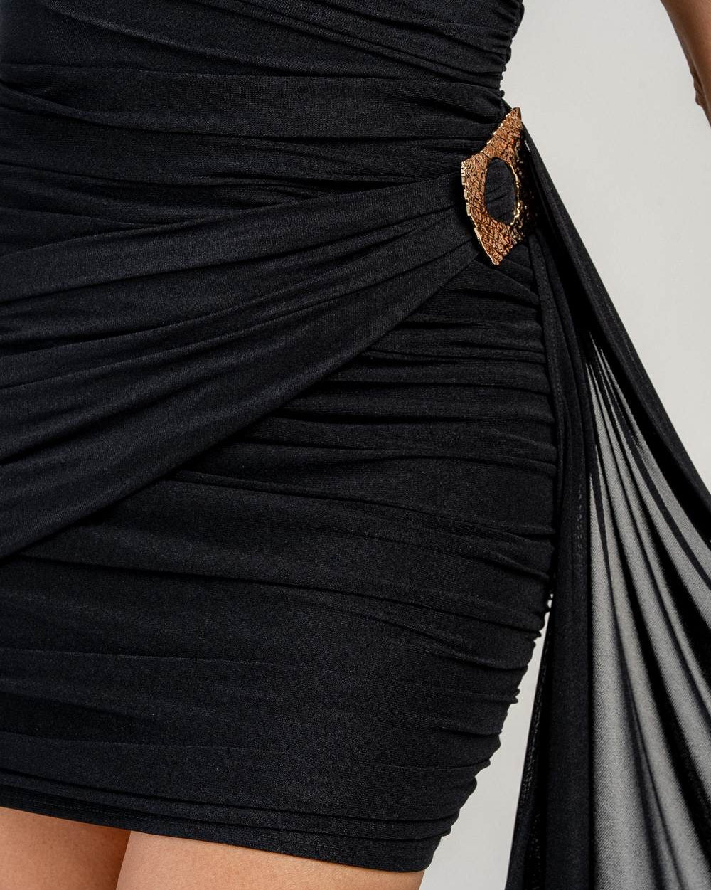 Close up of gold detail on black sweetheart mini dress