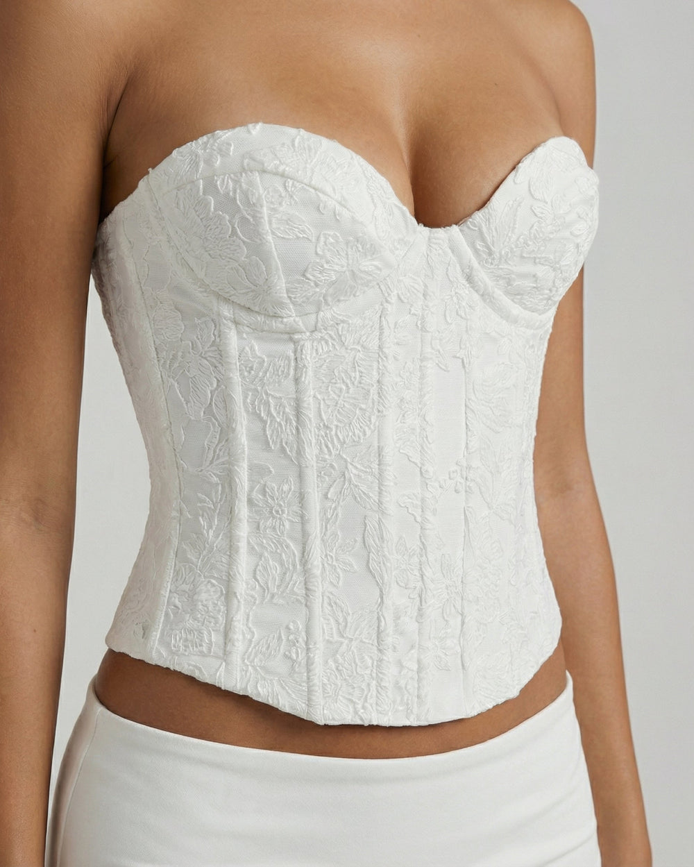 Close up view of floral embroidered white corset top