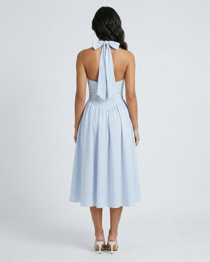Light blue dress with a halter neck and bow detail on a white background