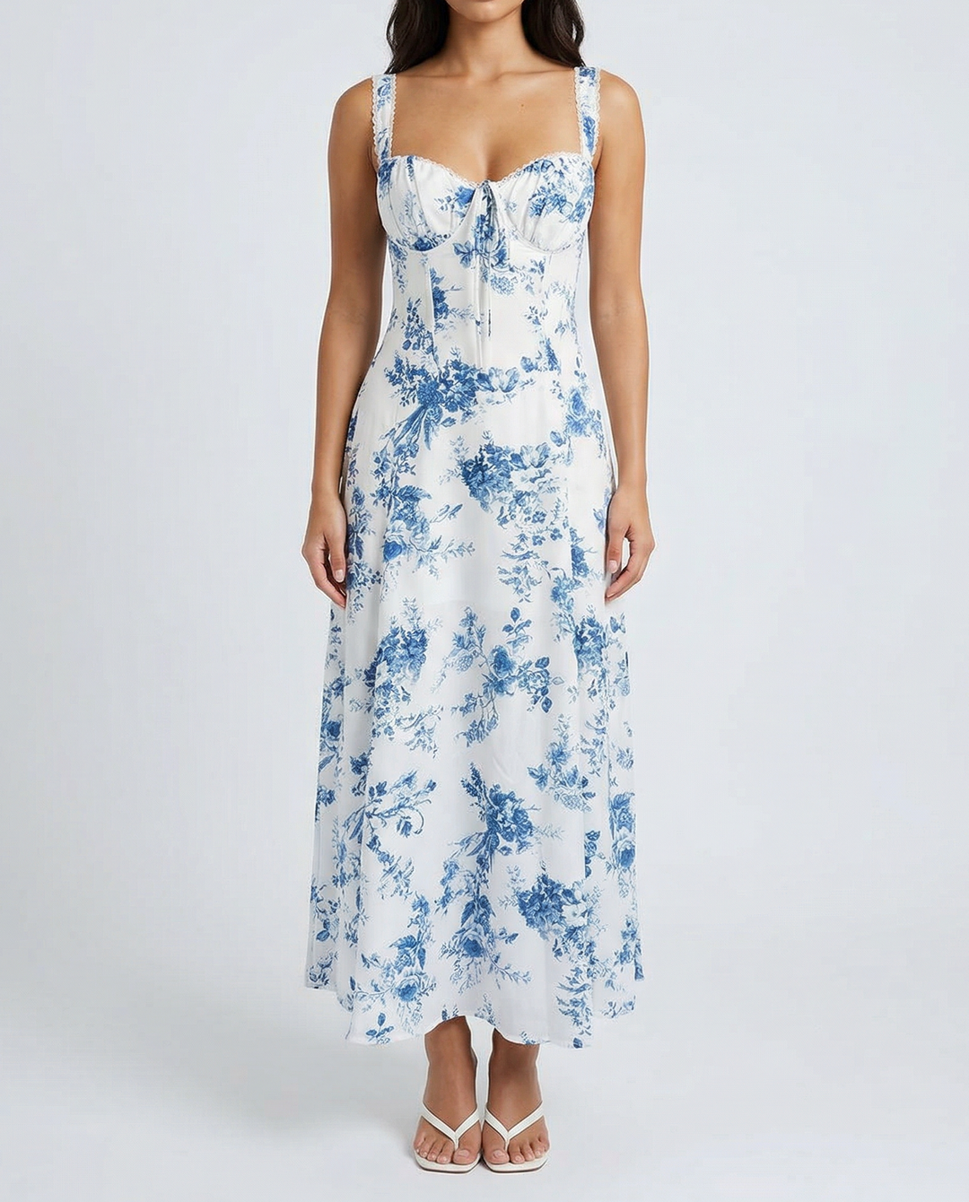 Woman wearing a white floral dress against a white background